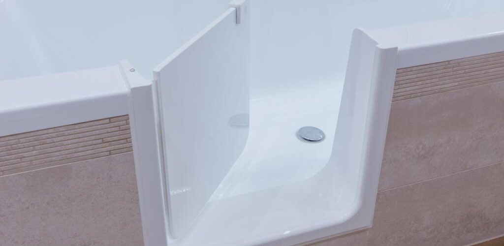 Nahaufnahme der geöffneten, barrierearmen Tür einer Badewanne, die einen einfachen Einstieg ermöglicht. Die helle Fliesenverkleidung ergänzt das moderne Badezimmerdesign.